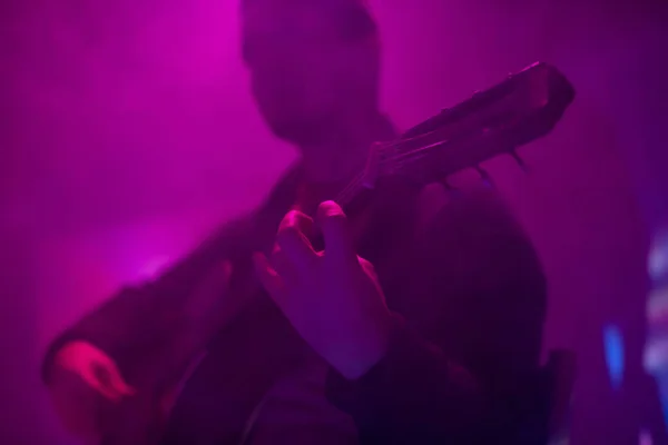형형색색의 안개낀 클럽에서 기타를 연주하는 음악가 — 스톡 사진