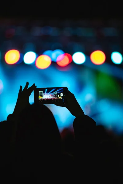 Person Mit Smartphone Und Silhouetten Von Konzertbesuchern Mit Bühnenbeleuchtung — Stockfoto