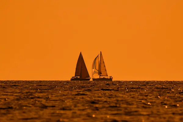 日落日出时间和海洋地平线下帆船的轮廓 — 图库照片