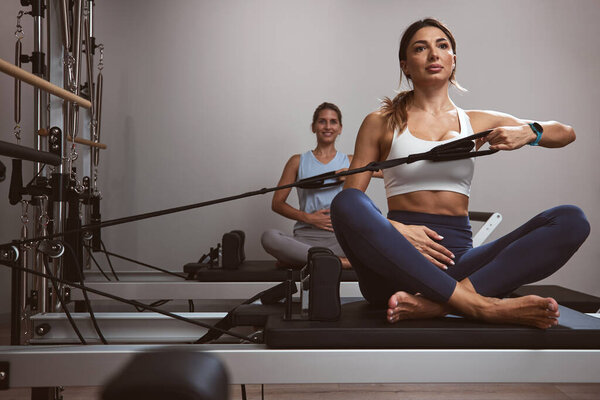 Молодые женщины занимаются в тренажерном зале
.