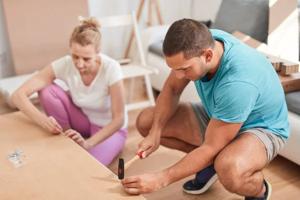 stock image Husband and wife assembling new furniture - home renovation concept.