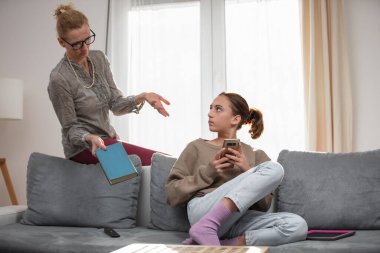 Annem akıllı telefondan video oyunu oynarken evde tembel bir ergen kızla sorun yaşıyor..