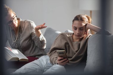 Annem akıllı telefondan video oyunu oynarken evde tembel bir ergen kızla sorun yaşıyor..