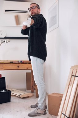 Yeni ahşap bir raf ve mobilya monte eden bir adam..