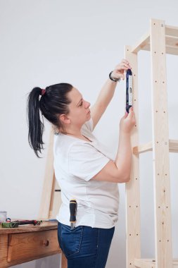 Yeni ahşap raf ve mobilyaları bir araya getiren kadın..