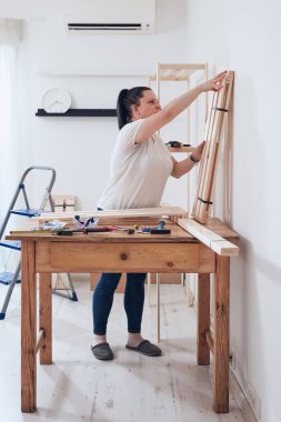 Yeni ahşap raf ve mobilyaları bir araya getiren kadın..