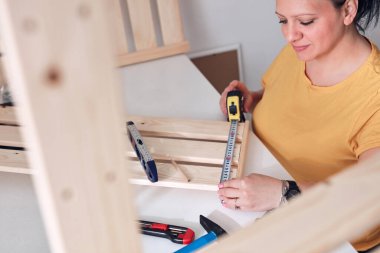 Yeni ahşap raf ve mobilyaları bir araya getiren kadın..