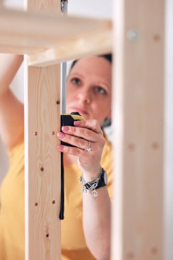 Yeni ahşap raf ve mobilyaları bir araya getiren kadın..