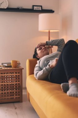 Midesi ve başı ağrıyan bir kadın..