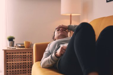 Midesi ve başı ağrıyan bir kadın..