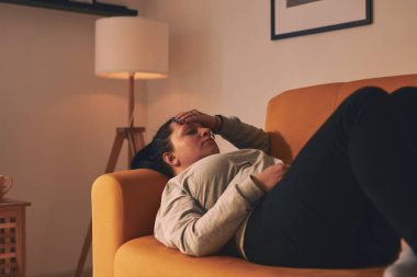 Midesi ve başı ağrıyan bir kadın..