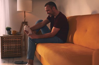 Evinde ayak ağrısı olan bir adam..