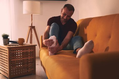 Evinde ayak ağrısı olan bir adam..