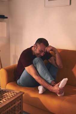 Evinde ayak ağrısı olan bir adam..
