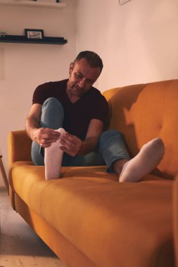 Evinde ayak ağrısı olan bir adam..