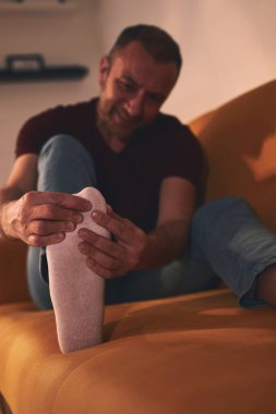 Evinde ayak ağrısı olan bir adam..