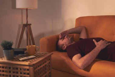 Midesi ve başı ağrıyan bir adam..