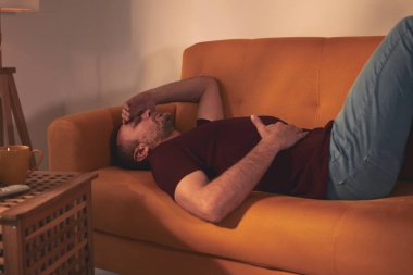 Midesi ve başı ağrıyan bir adam..