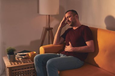 Midesi ve başı ağrıyan bir adam..