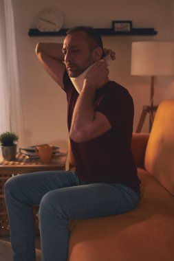 Servikal yakalı ve boynu ağrıyan bir adam..