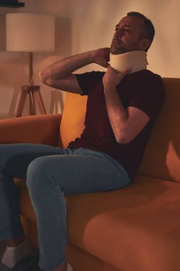 Servikal yakalı ve boynu ağrıyan bir adam..