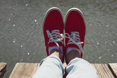 Kırmızı pabuçlu bir insan göl tahtasında dinleniyor..