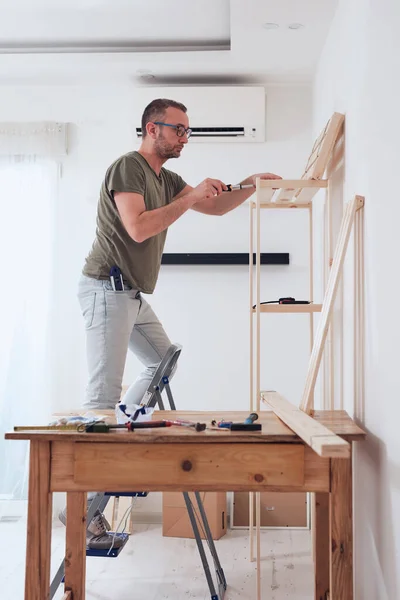 男人在公寓里组装新的木架和家具 — 图库照片