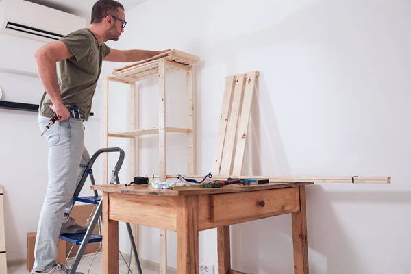 Hombre Montando Nuevos Estantes Madera Muebles Apartamento — Foto de Stock