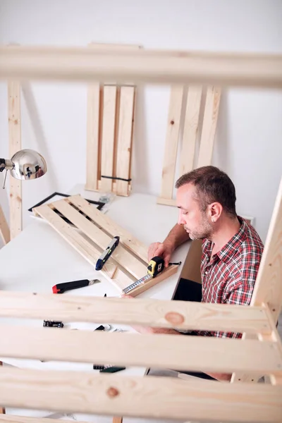 Mężczyzna Montuje Nowe Drewniane Półki Meble Mieszkaniu — Zdjęcie stockowe