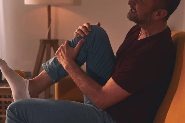 Homme Avec Douleur Genou Assis Sur Canapé Maison — Photo