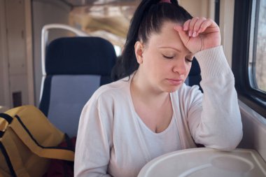 Bir kadın seyahat ederken tren koltuğunda uyuyor..