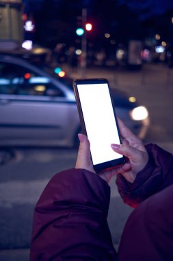 Cep telefonu tutan ve karşıdan karşıya geçen kadın..