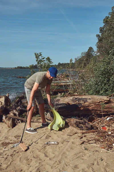 stock image Volunteer and environmental activist cleaning dirty river shore filled with trash.