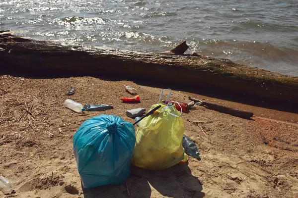 Collected trash thrown away on river shore.