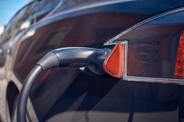 stock image EV car on a home charging cable on the street.