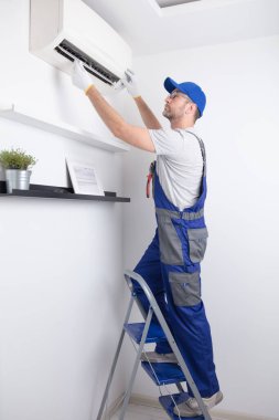 Servis elemanı havalandırmayı temizliyor..
