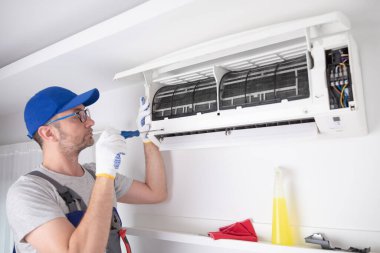 Service guy cleaning and maintaining air condition unit. clipart