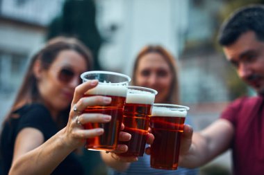 İnsanlar ellerinde bira bardakları tutarak yaz tatilinin tadını çıkarıyorlar..