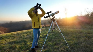 Amatör astronom dürbün ve teleskopla gökyüzünü gözlemliyor..