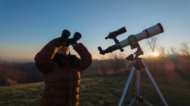 Amatör astronom dürbün ve teleskopla gökyüzünü gözlemliyor..