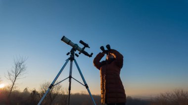 Amatör astronom dürbün ve teleskopla gökyüzünü gözlemliyor..