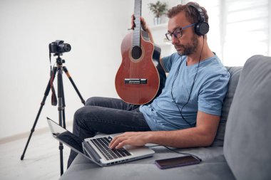 İnternet vlog web sitesi dersleri için video dersleri ve dersler hazırlayan gitarist.