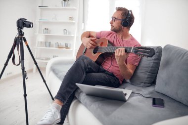 İnternet vlog web sitesi dersleri için video dersleri ve dersler hazırlayan gitarist.