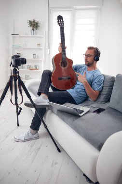 İnternet vlog web sitesi dersleri için video dersleri ve dersler hazırlayan gitarist.