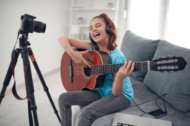 İnternet vlog web sitesi dersleri için video dersleri ve özel ders hazırlayan çocuk gitarist.