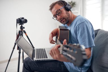 İnternet vlog web sitesi dersleri için video dersleri ve dersler hazırlayan gitarist.