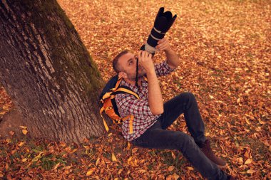 Dürbün ve kamera kullanan adam doğada kuşları ve hayvanları izliyor..