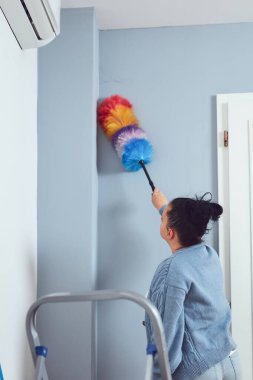 Dairesini süpürgeyle temizleyen kadın..