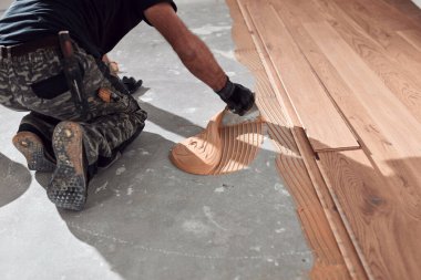 Profesyonel tamirci yeni bir daireye kaplama döşeme kuruyor..