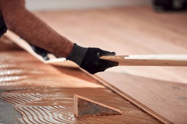 Profesyonel tamirci yeni bir daireye kaplama döşeme kuruyor..